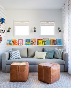 a living room filled with lots of furniture next to two windows and pictures on the wall