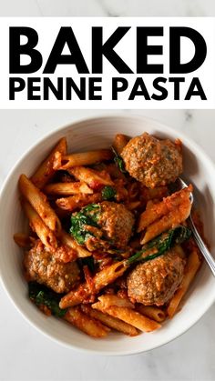 baked penne pasta in a bowl with meatballs and spinach