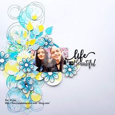 a scrapbook page with two women in the center and blue flowers on the bottom