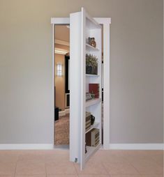 an open door in the middle of a room with white walls and tile flooring