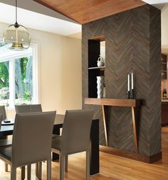 a dining room table and chairs in front of a wooden wall