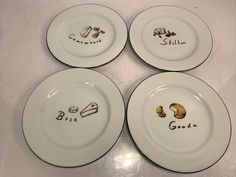 four white plates with different designs on them