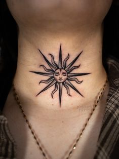 a woman's neck with a sun tattoo on the top and bottom part of her chest