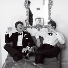 two men in tuxedos are sitting on a couch and one man has his mouth open