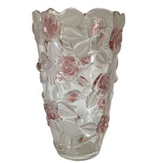 a clear glass vase with pink flowers on the outside and inside, sitting on a white surface