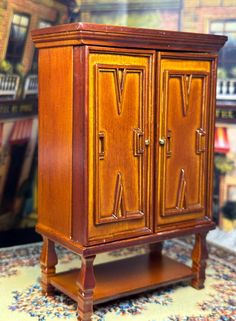 a small wooden cabinet sitting on top of a carpeted floor next to a wall