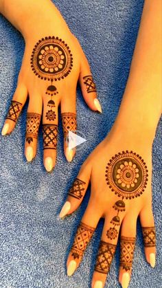 two hands with henna tattoos on them