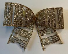 a close up of a glitter bow on a white surface