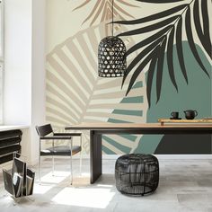 a dining room with a table and chairs in front of a palm leaf wall mural