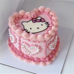 a hello kitty cake with pink frosting and hearts