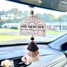 a car dashboard with a sign hanging from it's dash board that says, his mercies are new energy mommy