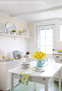 a white kitchen with yellow flowers on the table