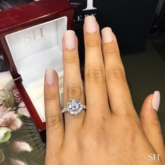 a woman's hand with a ring on it and an engagement ring in the box