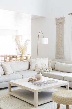 a living room with white couches and pillows