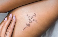 a close up of a woman's stomach with tattoos on her legs and flowers