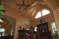 a living room with wooden walls and ceiling fan