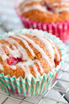 two muffins with icing sitting on a cooling rack