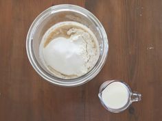 a blender filled with ingredients on top of a wooden table next to a measuring cup