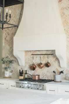 a stove top oven sitting inside of a kitchen next to a wall mounted range hood