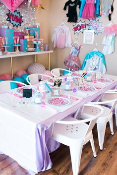 a party table set up with pink and blue decorations