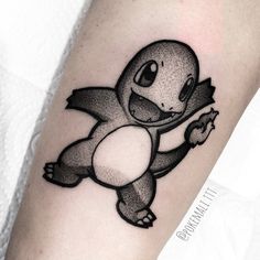 a black and white pokemon tattoo on the arm