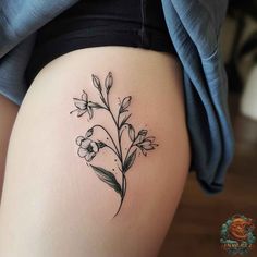 a small flower tattoo on the thigh