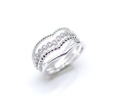 a white gold ring with three rows of diamonds on the sides and an open band