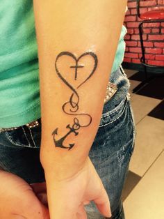 a woman's arm with an anchor and heart tattoo on it