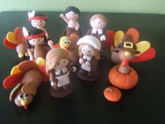 a group of thanksgiving figurines sitting on top of a black table next to each other