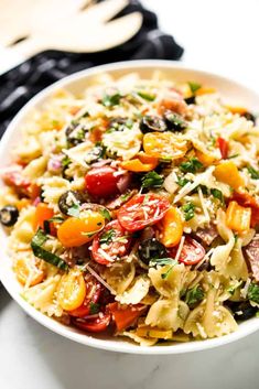 a white bowl filled with pasta and vegetables