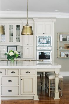 a kitchen with white cabinets and an island