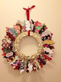 a christmas wreath made out of different types of paper and magnets hanging on the wall