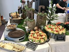 an assortment of food is displayed on a table with other foods and desserts around it