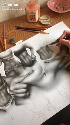 a person is drawing on paper with colored pencils