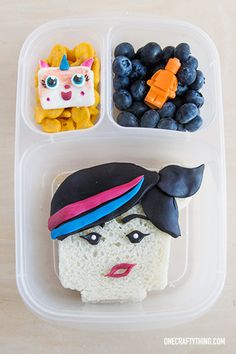 a plastic container filled with rice krispy kreme and blueberries next to fruit