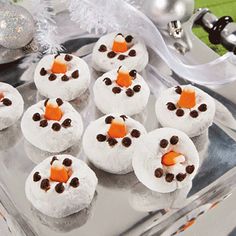 there are many snowmen made out of cookies on the tray with decorations in the background