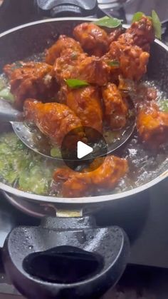 a pan filled with meat and broccoli on top of a stove