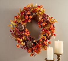 a wreath and two candles on a table