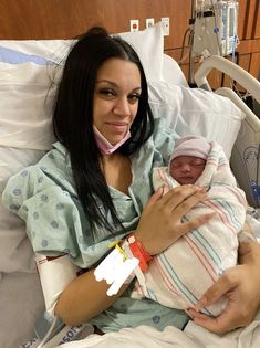 a woman holding a baby in a hospital bed