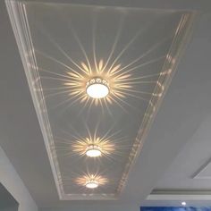 the ceiling in this room is decorated with white and gold lights, which are shining brightly