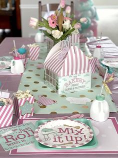 a table set up for a baby shower with pink, green and white decorations on it