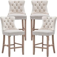 a set of four white upholstered barstools with studded trimmings