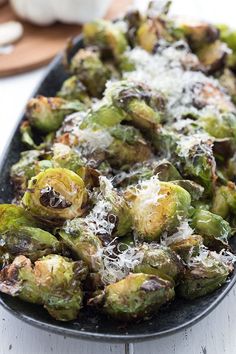 brussel sprouts with parmesan cheese on top in a pan