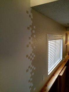 an empty room with white blinds on the window sill and wooden counter top in front of it