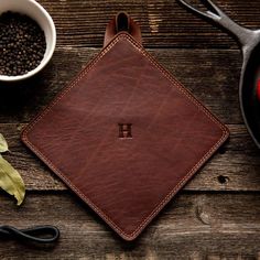 a brown leather coaster sitting on top of a wooden table next to a bowl of beans