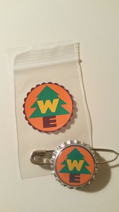 two bottle caps with the word w e on them are sitting next to each other