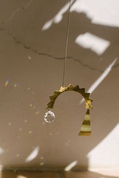 a wind chime hanging from a rope in the air with sunlight shining on it