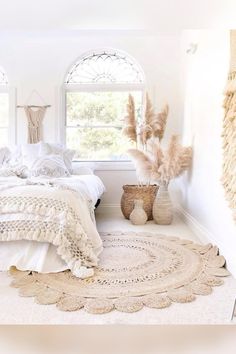 a bedroom with white bedding and rugs on the floor