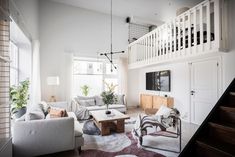 a living room filled with furniture and a stair case