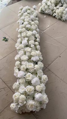 white flowers are laid out on the floor to be used as a decoration for a wedding ceremony